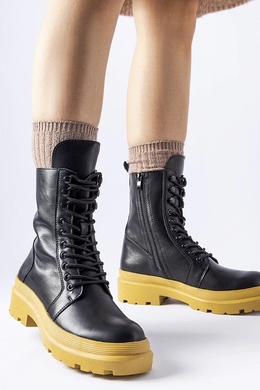 Schwarze Winterstiefel auf gelber...
