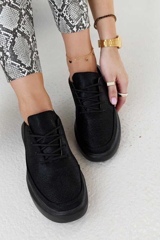 Schwarze Damen-Sneaker auf der... Schwarze Damen-Sneaker auf der...