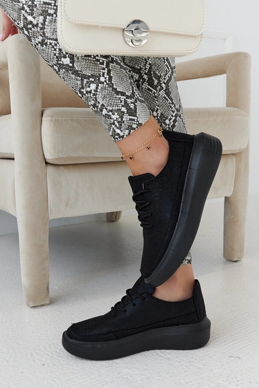 Schwarze Damen-Sneaker auf der... Schwarze Damen-Sneaker auf der...