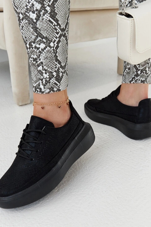 Schwarze Damen-Sneaker auf der... Schwarze Damen-Sneaker auf der...