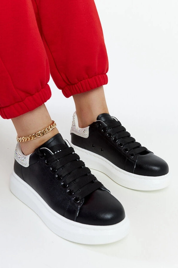 Schwarze Sneakers auf der...