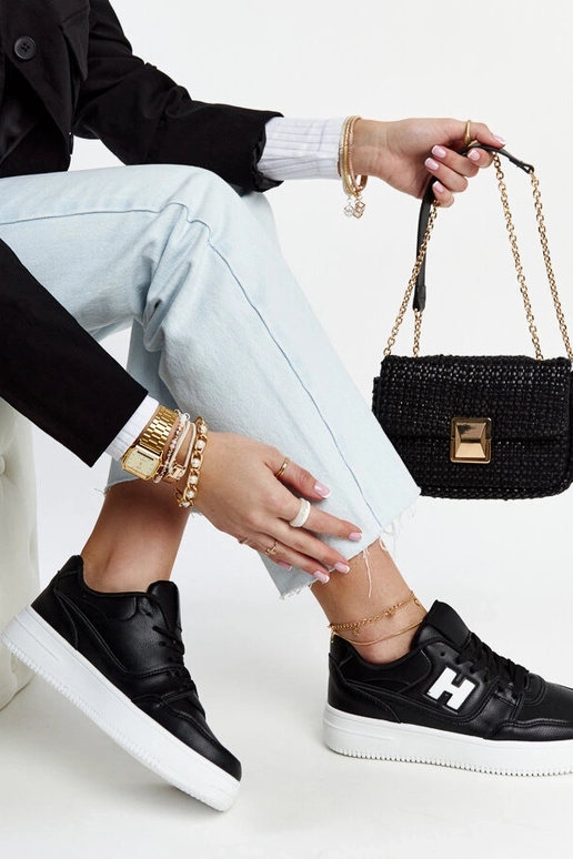 Schwarze Sneaker auf weißem Plateau...