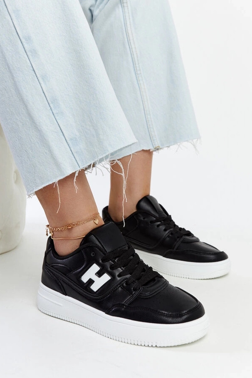 Schwarze Sneaker auf weißem Plateau...