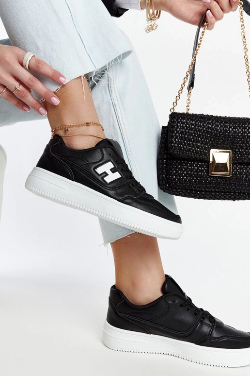 Schwarze Sneaker auf weißem Plateau...