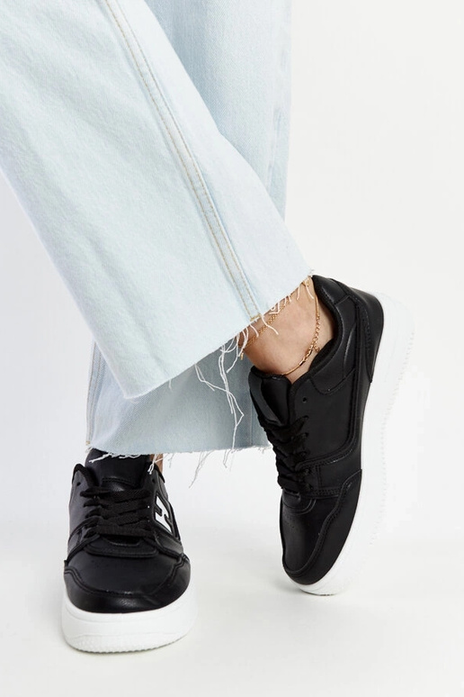 Schwarze Sneaker auf weißem Plateau...