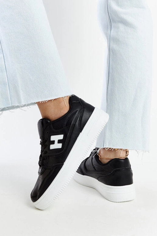 Schwarze Sneaker auf weißem Plateau...