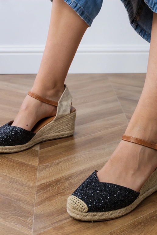 Schwarze glänzende Sandalen auf der...