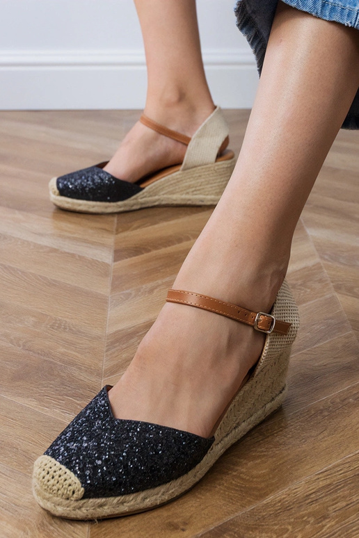 Schwarze glänzende Sandalen auf der...