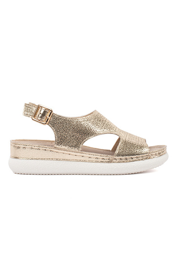 Goldene Sandalen auf hellem...