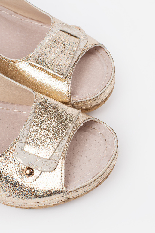 Goldene Sandalen auf niedrigem Keil